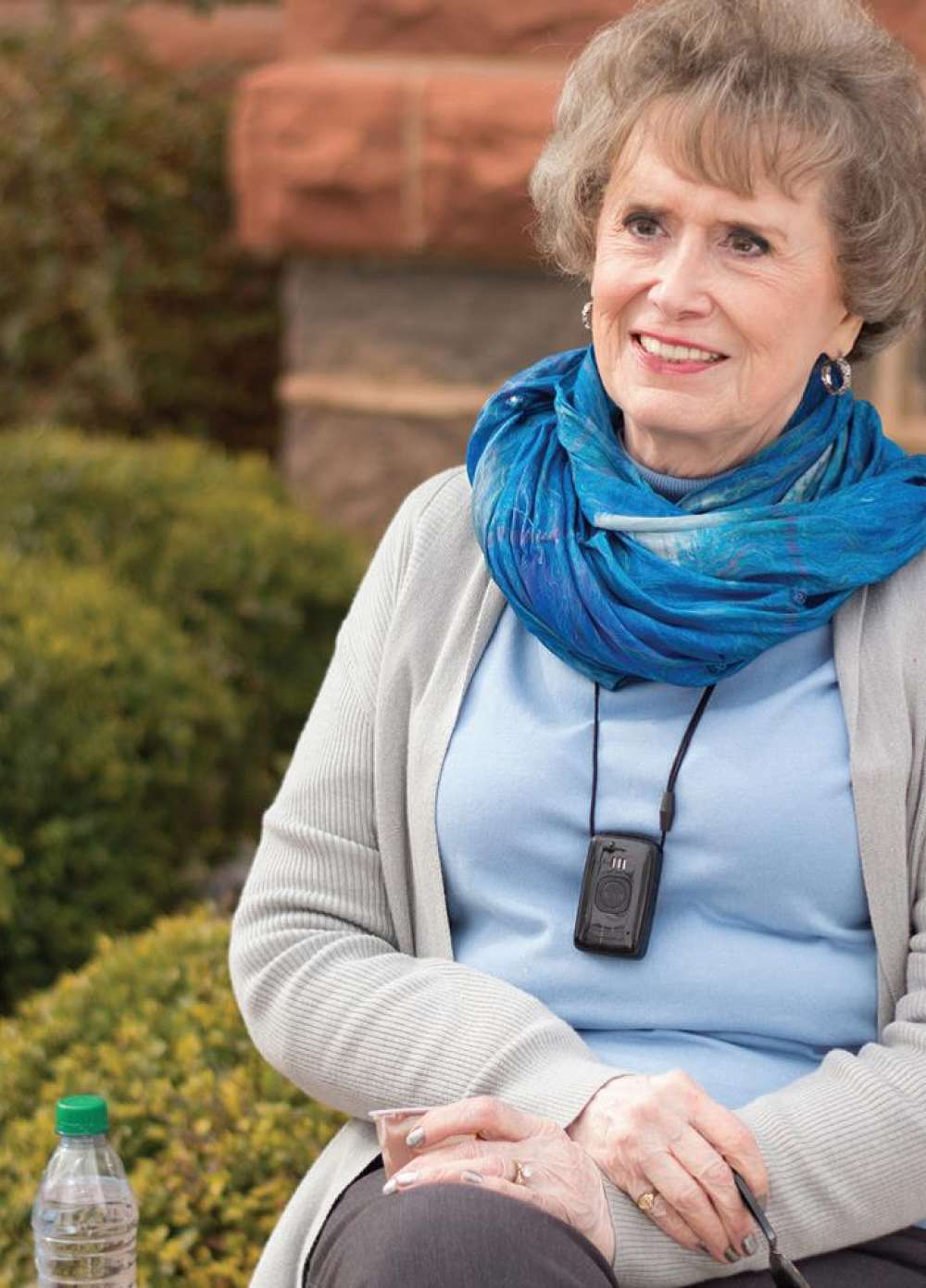 A woman wearing a carelink device around her neck.