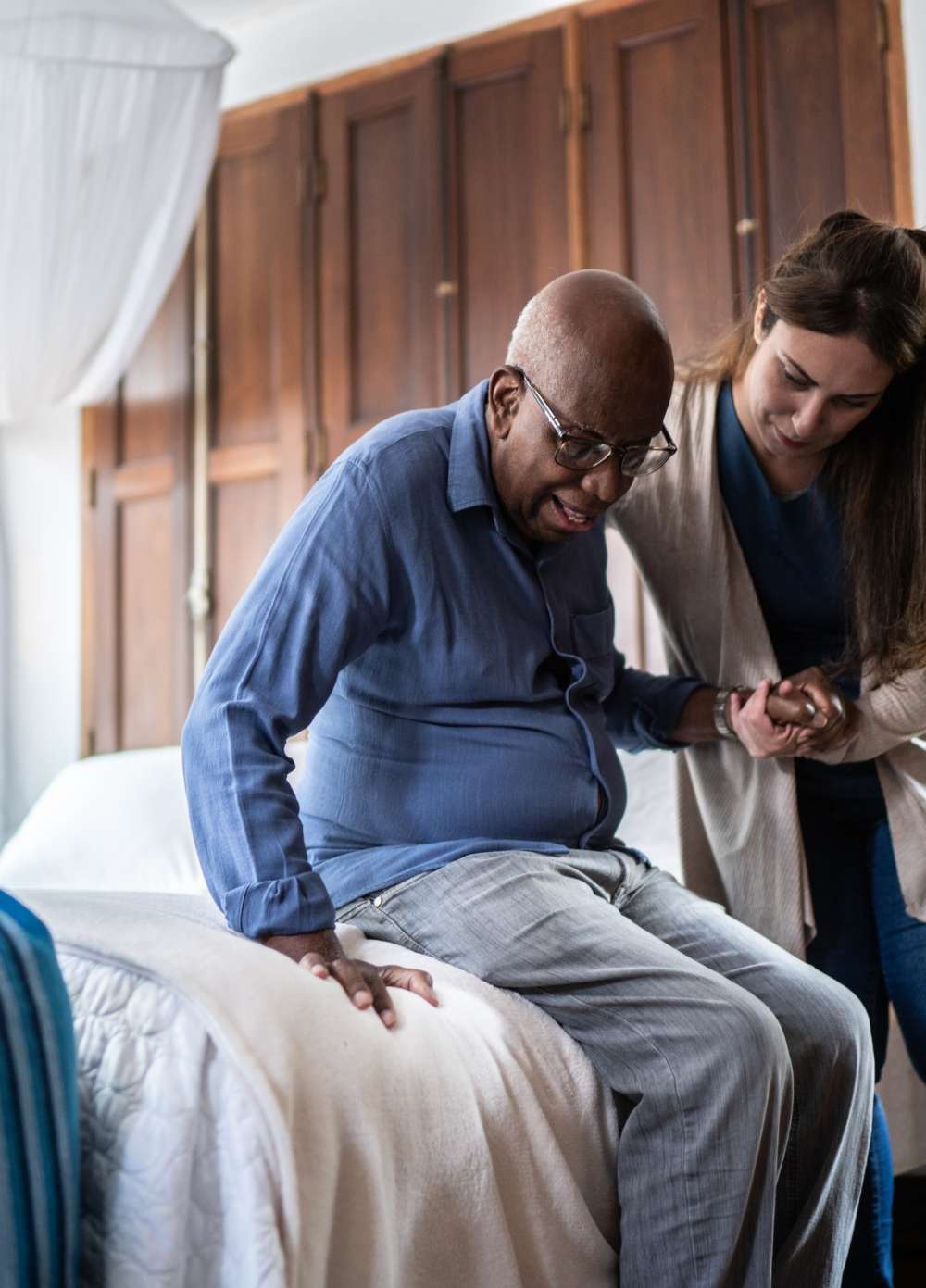 Nurse helping man out of chair